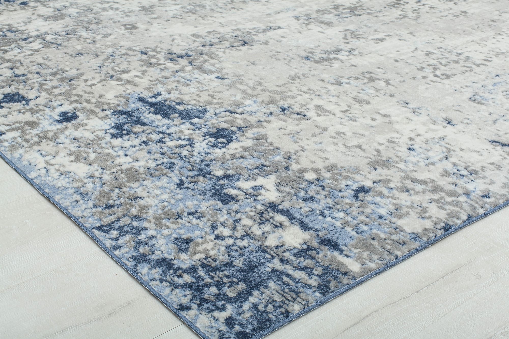 Close-up view of a Prescott mottled cobalt blue rug, showing detailed texture and corner placement on a light-colored floor.